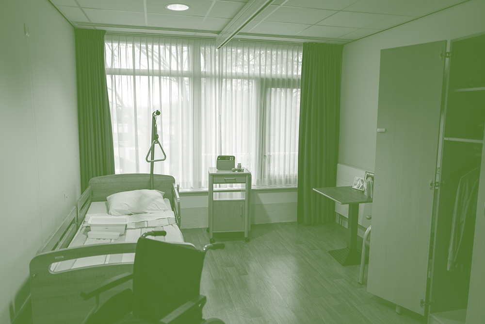 Lege zorgkamer met bed en rolstoel