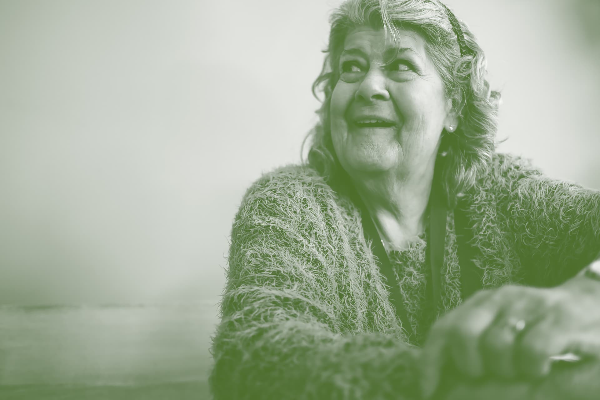 Lachende oudere vrouw in gesprek aan tafel
